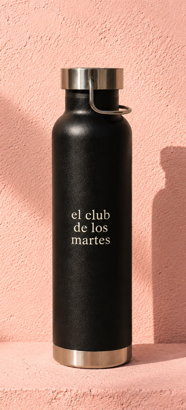 Botella negra personalizada con el texto El Club de los Martes sobre fondo rosa